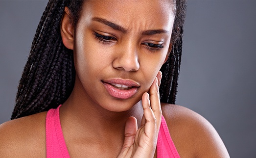 Woman in pain holding jaw