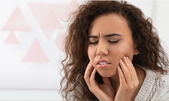 Woman in pain holding jaw