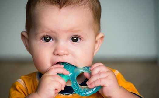 Child chewing on teething ring