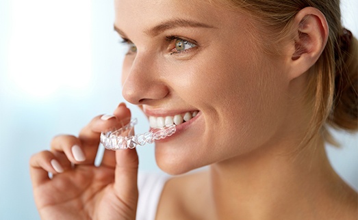 Woman placing Invisalign tray