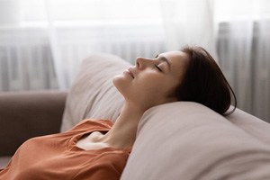 Woman in orange shirt resting at home