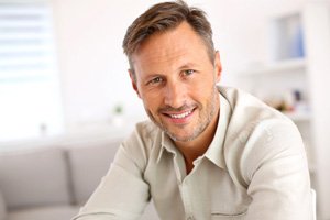 Man in white button-up shirt sitting and smiling