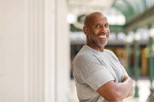 smiling man standing with his arms crossed