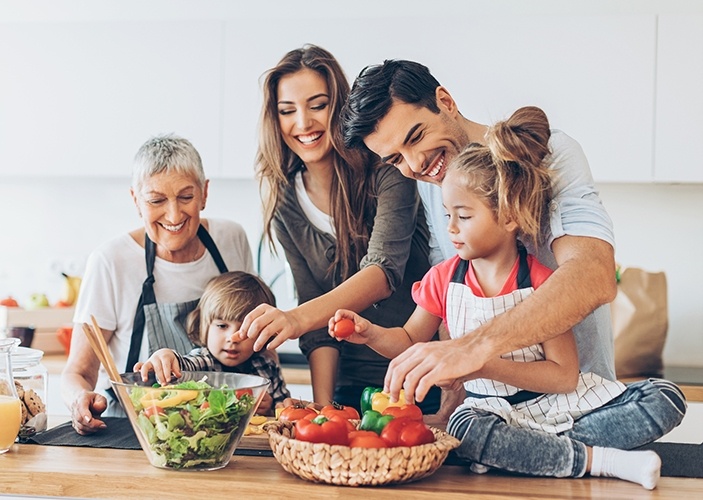 Parents kids and grandma making dinner together