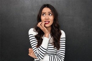 A woman biting her nails 