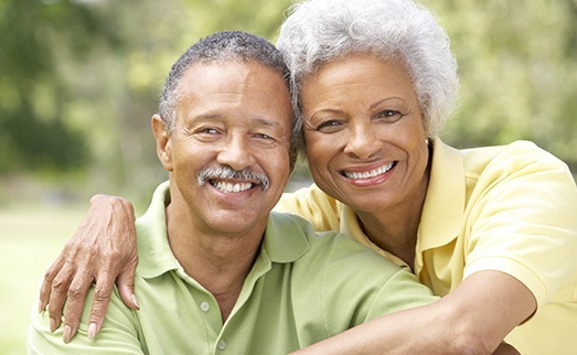 Older man and woman smiling outdoors