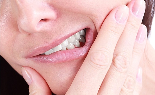 Closeup of patient in pain holding jaw