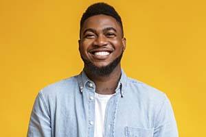 man smiling in front of a yellow background